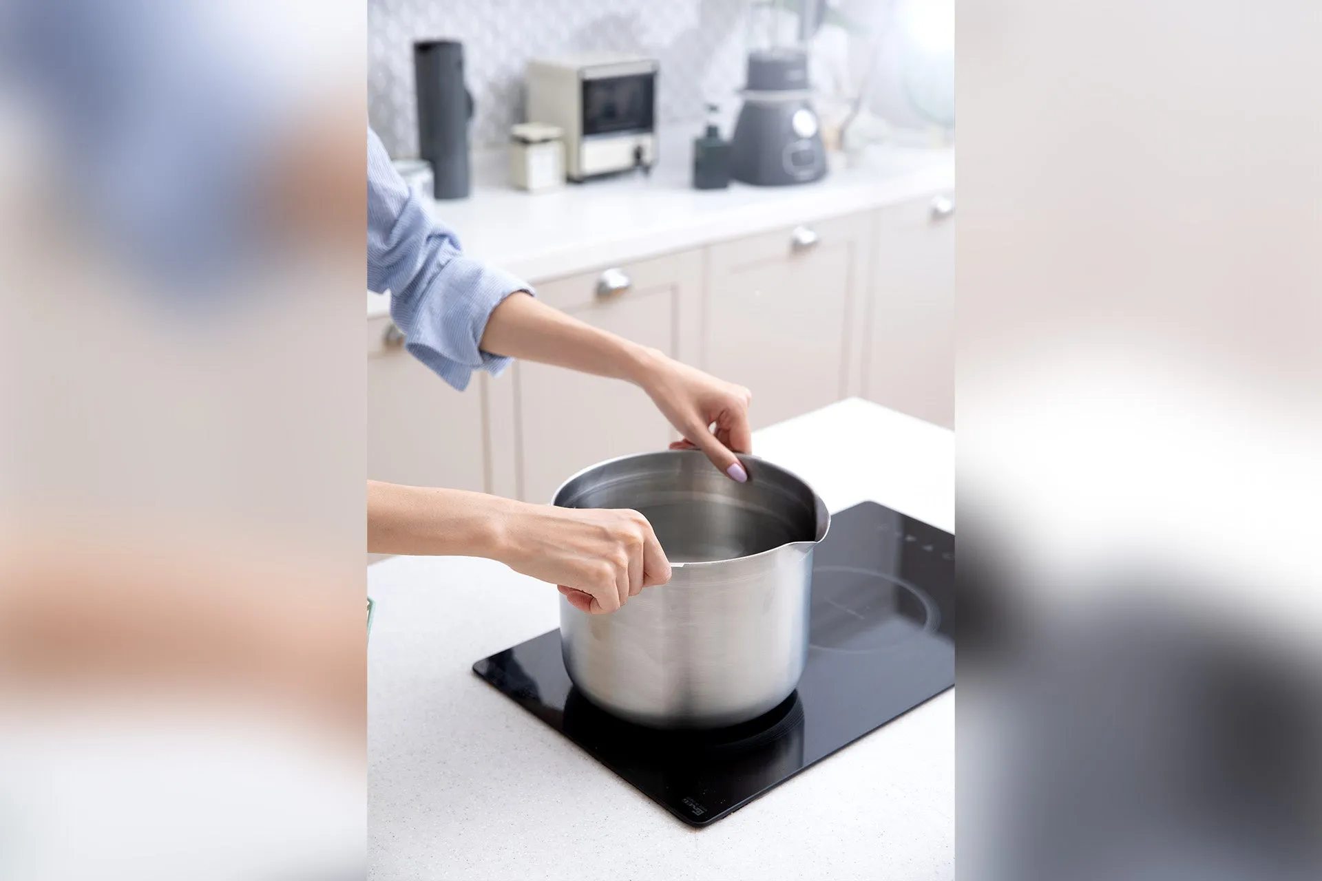 調理中の鍋を持っている女性