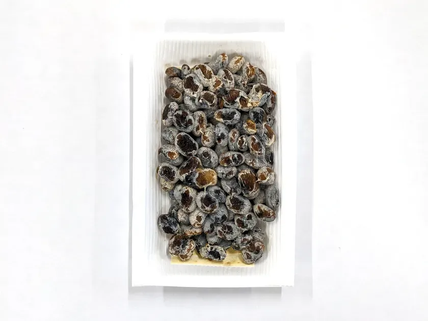 パックに入った納豆のクローズアップ写真。白い背景に置かれています。