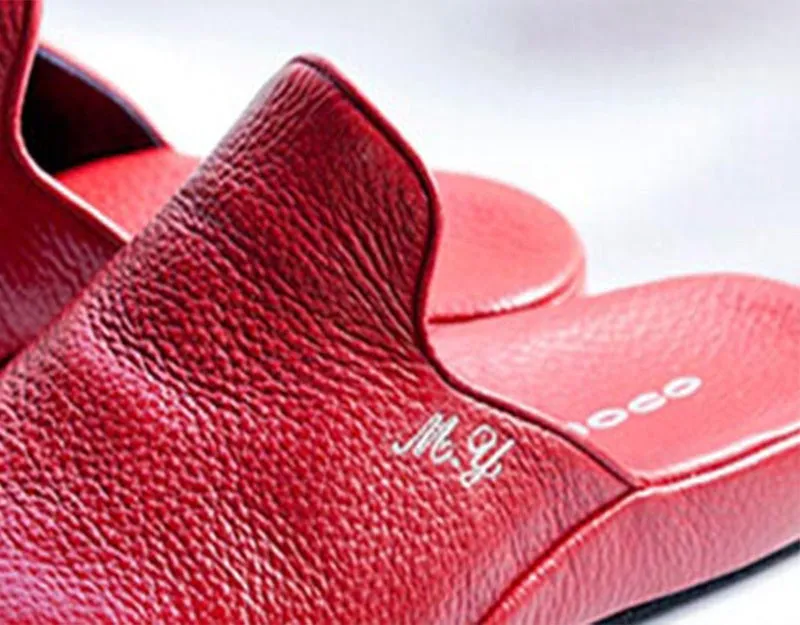 赤いスリッパのクローズアップ、イニシャルあり