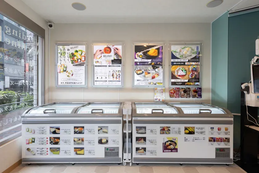 店内には、冷蔵ショーケースと商品の写真が飾られたポスターが並んでいます。