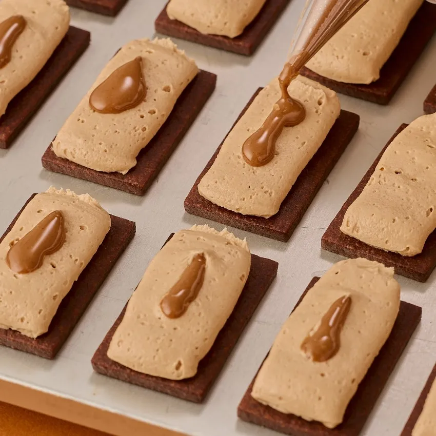 クリームとチョコレートソースがトッピングされたクッキー