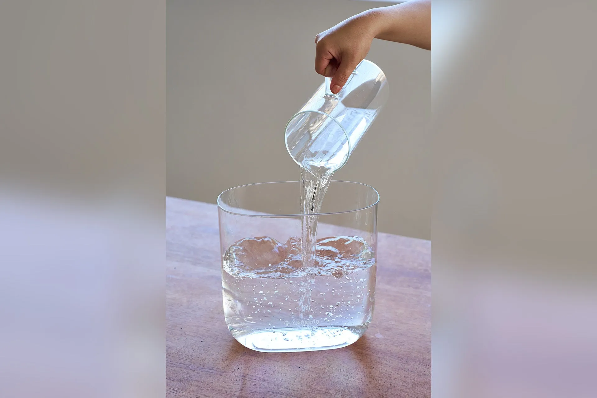 ピッチャーからグラスに水が注がれる様子