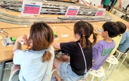 子供たちが鉄道模型を操作している様子