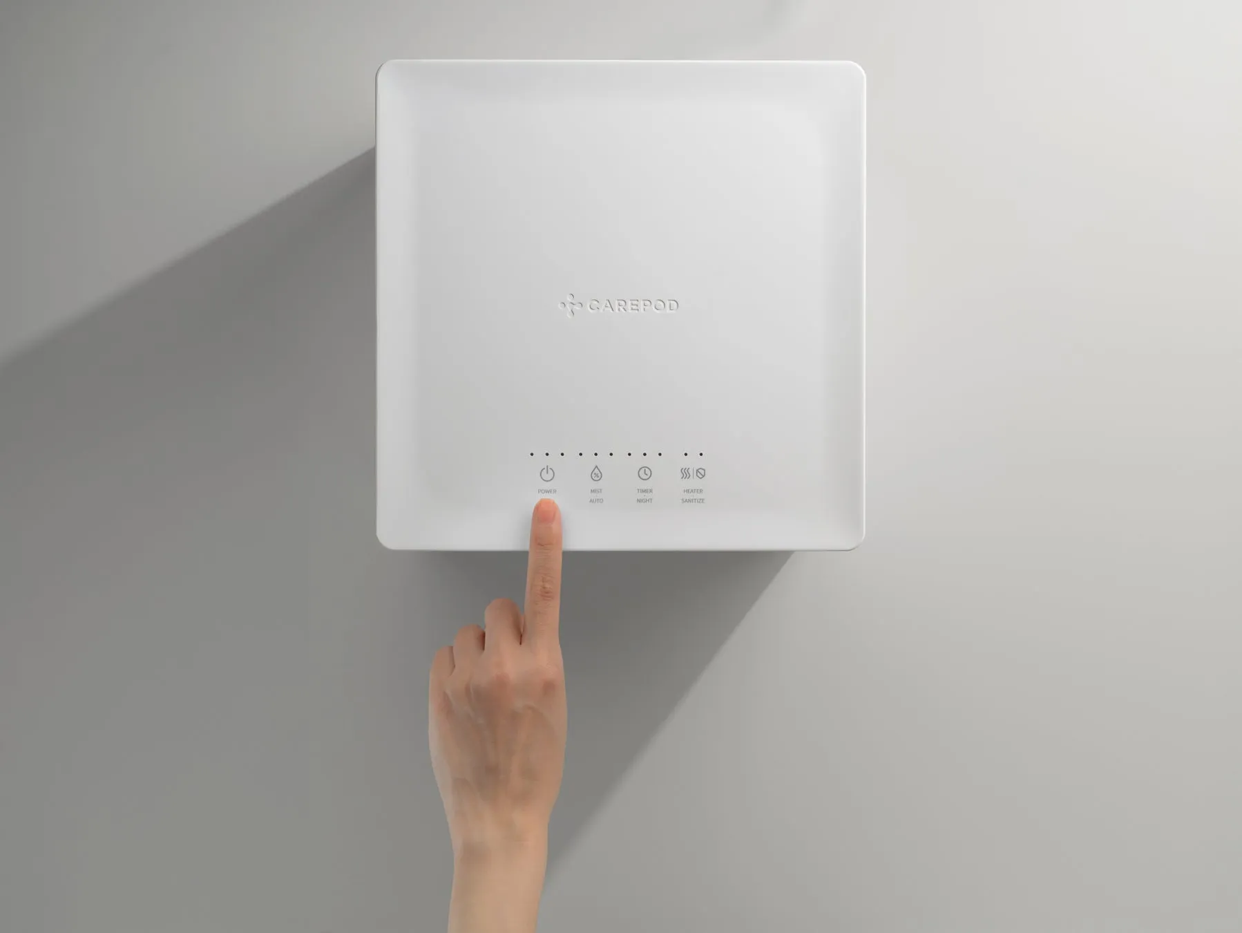 白いデバイスに手が触れている様子