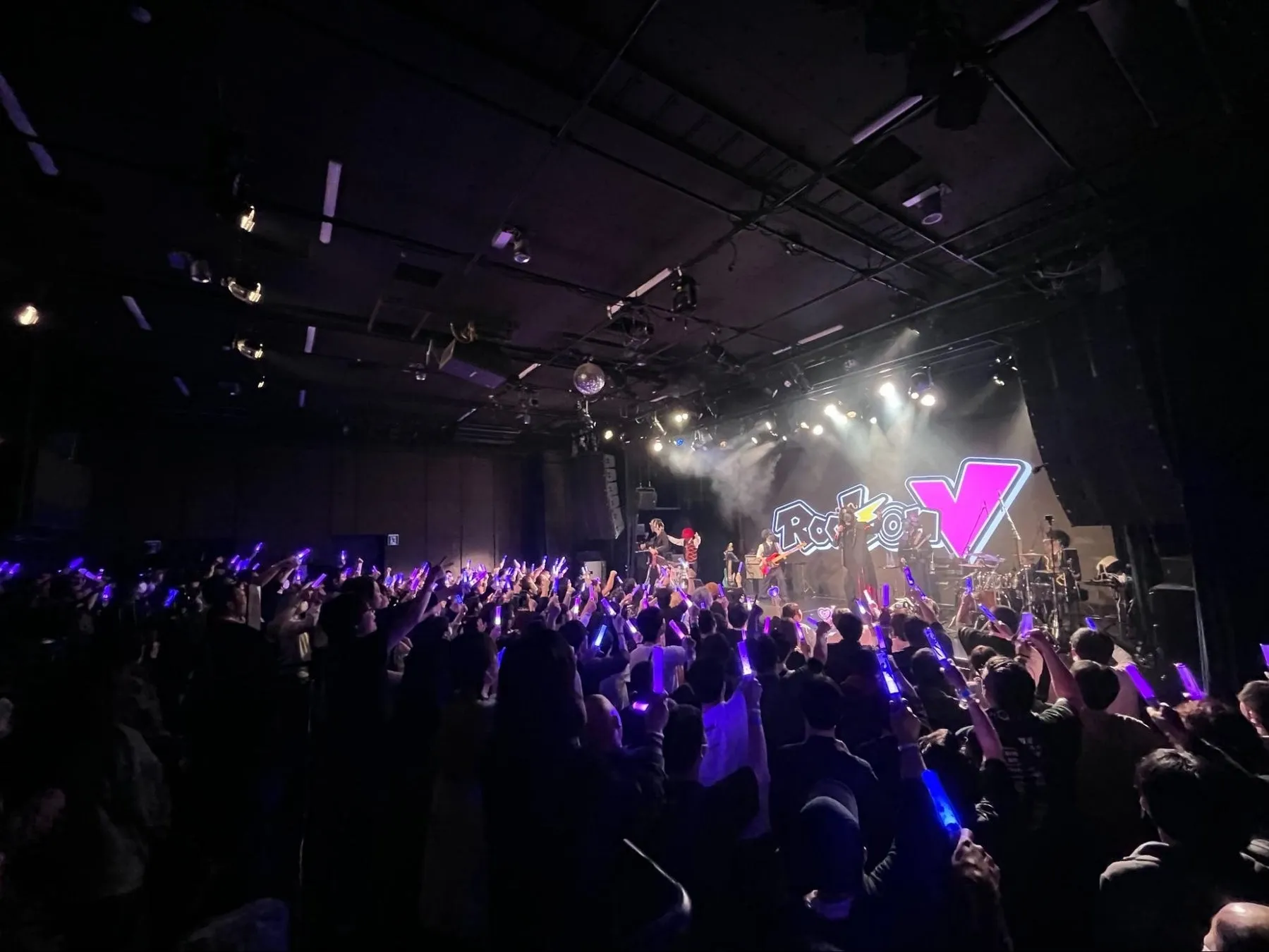 ライブ会場の様子。観客がペンライトを振って盛り上がっている。