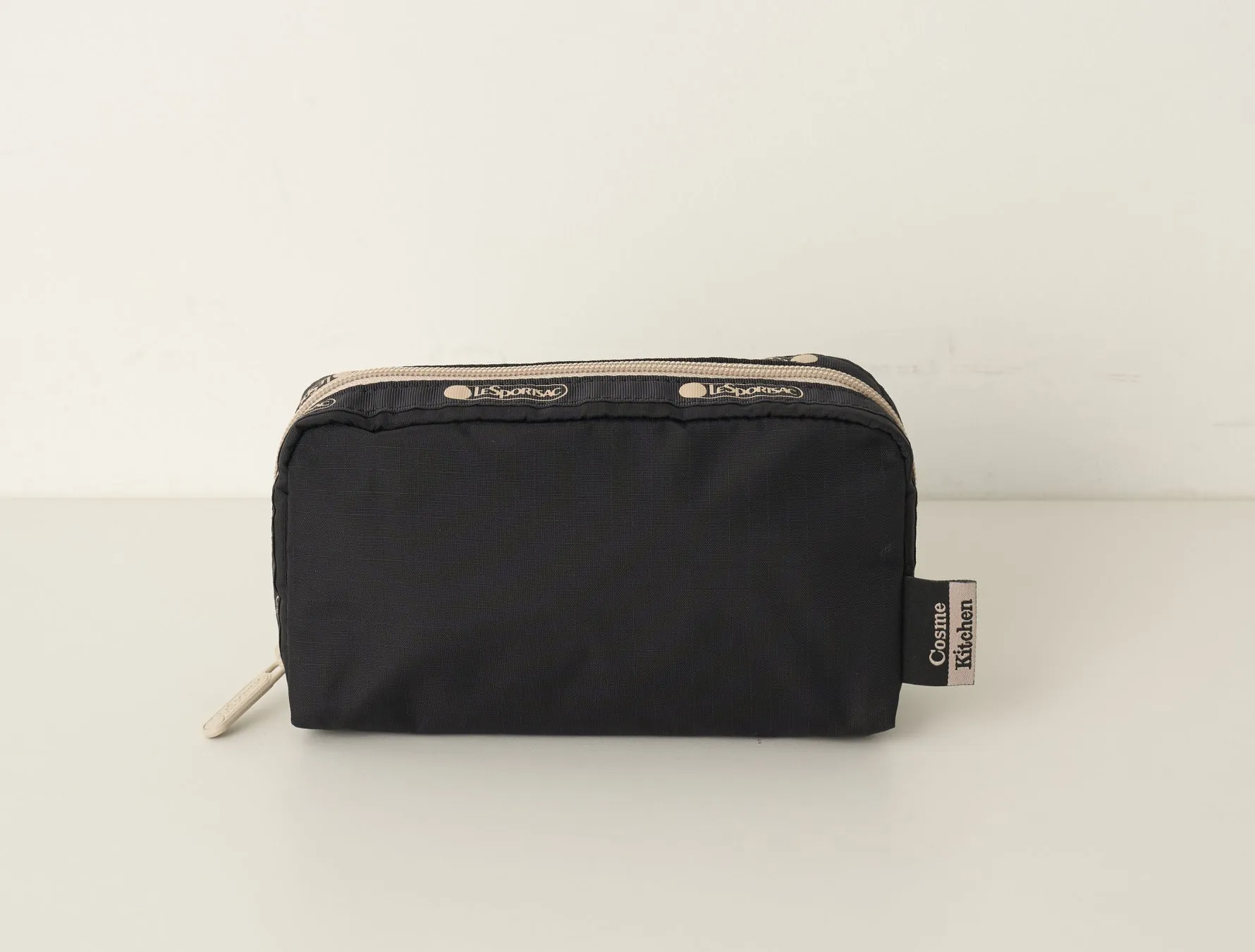 黒いポーチが白い背景に置かれた写真です。