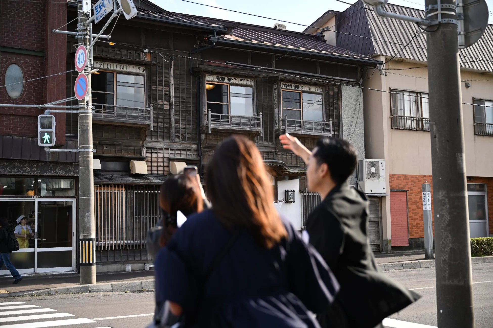 木造の古い建物を見学する人々