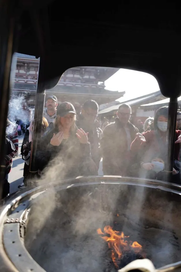 火の周りに集まり煙を浴びる人々