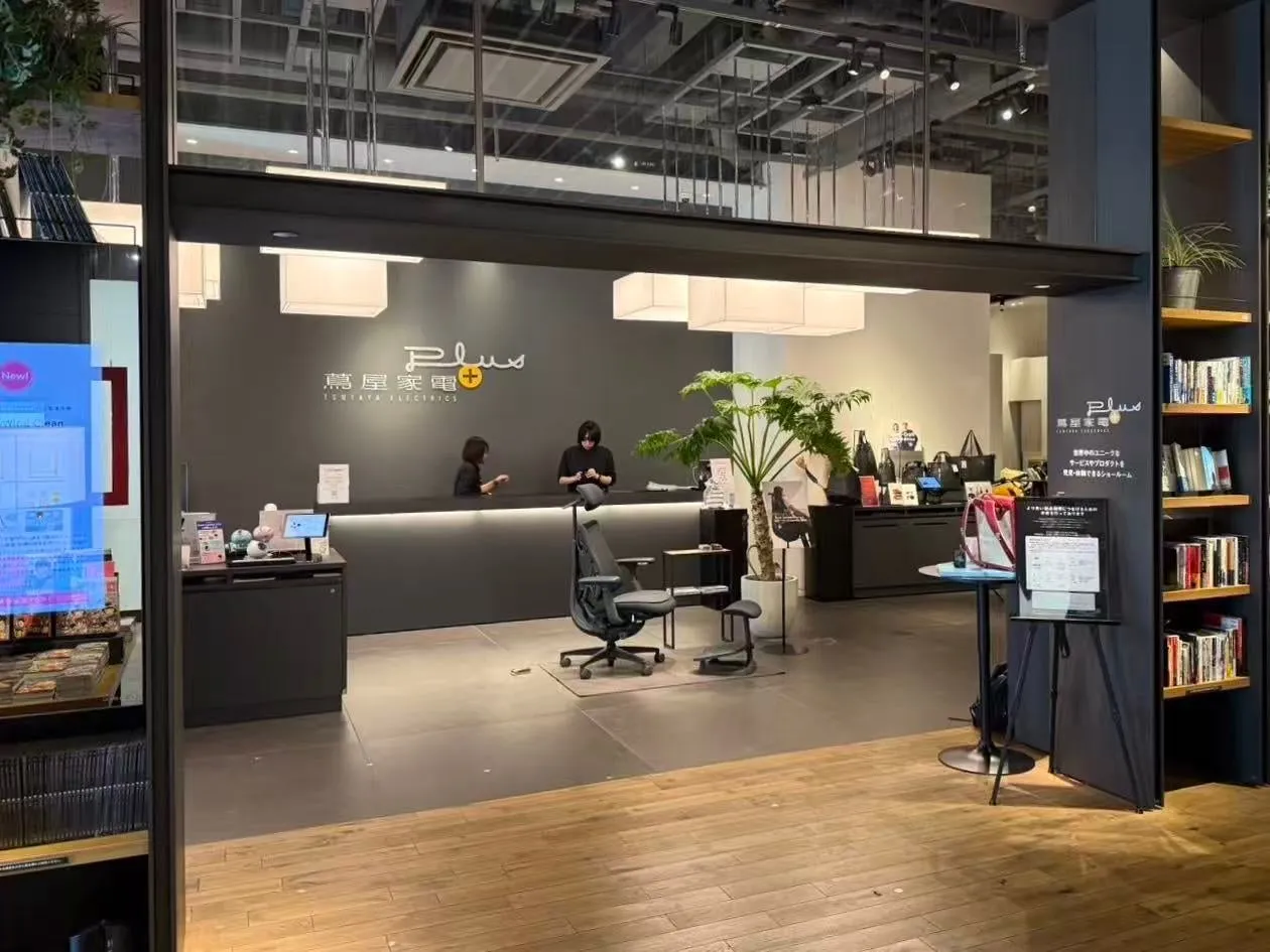 蔦屋家電の店舗内部の様子。レジカウンターには店員がおり、奥には商品が陳列されている。店内には植物や本棚も配置され、洗練された空間を演出している。