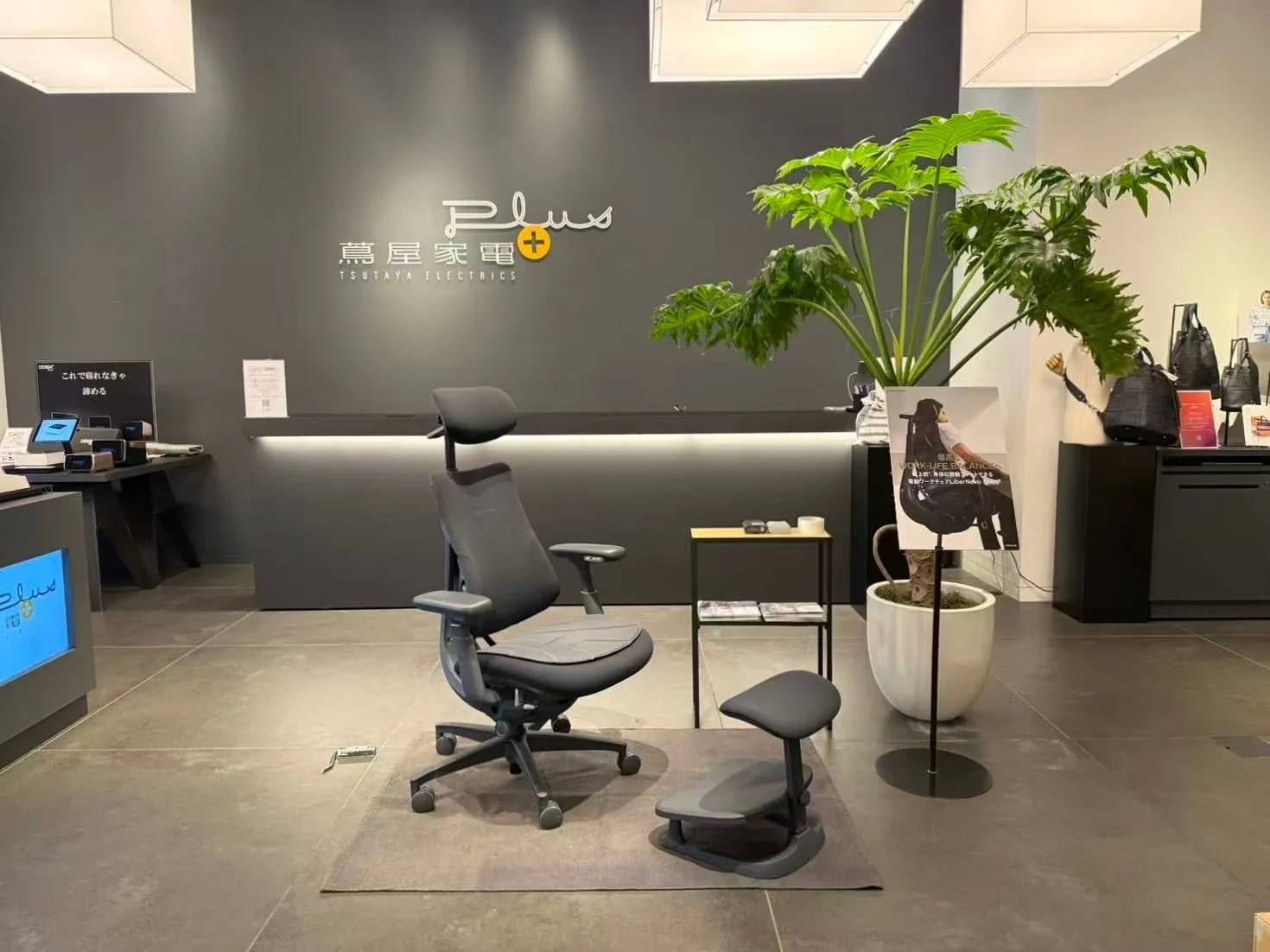 蔦屋家電プラスの店内の様子。エルゴヒューマンのオフィスチェアとフットレストが配置され、観葉植物や商品ディスプレイが置かれている。