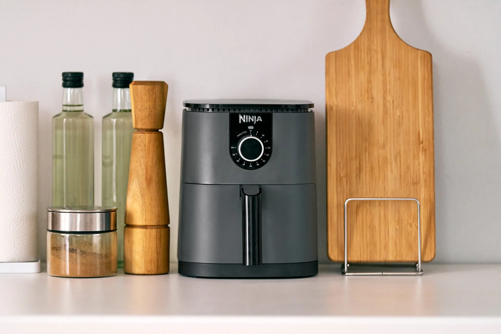 キッチンカウンターに置かれたエアフライヤー、まな板、調味料などの写真