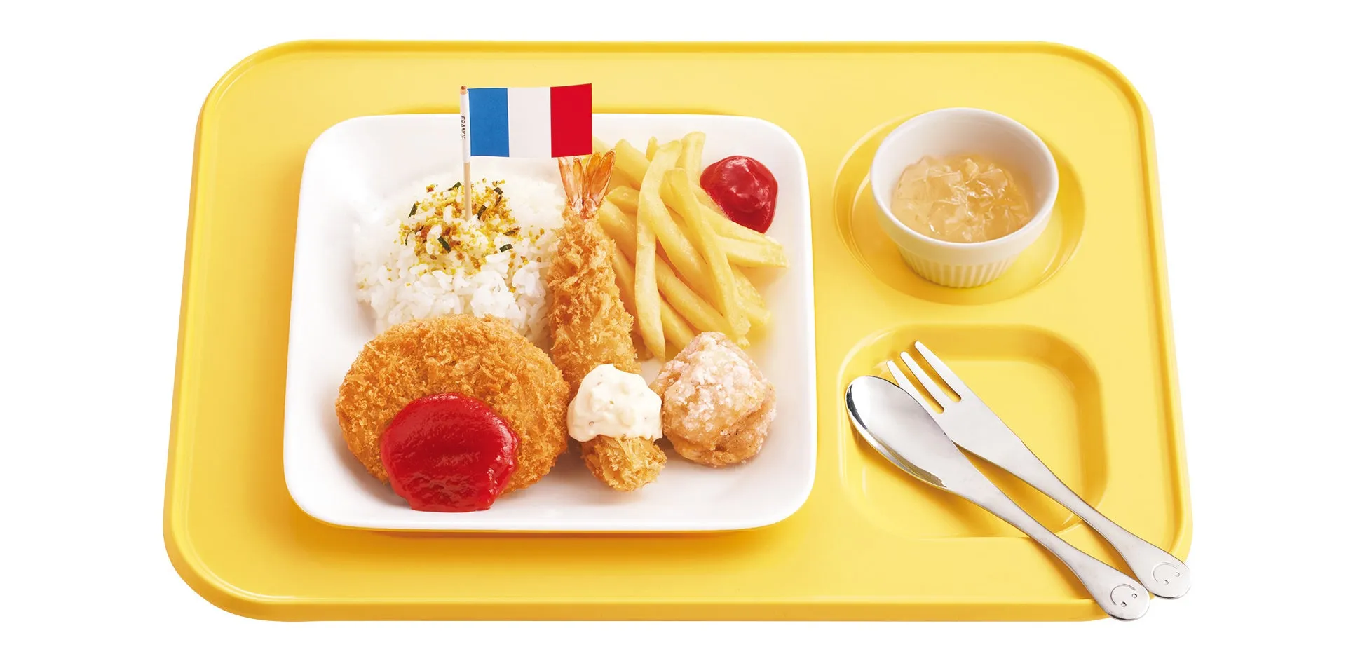 黄色いランチトレイに、ご飯、エビフライ、フライドポテト、コロッケ、鶏の唐揚げ、ゼリー、フランス国旗が添えられた給食のイメージ