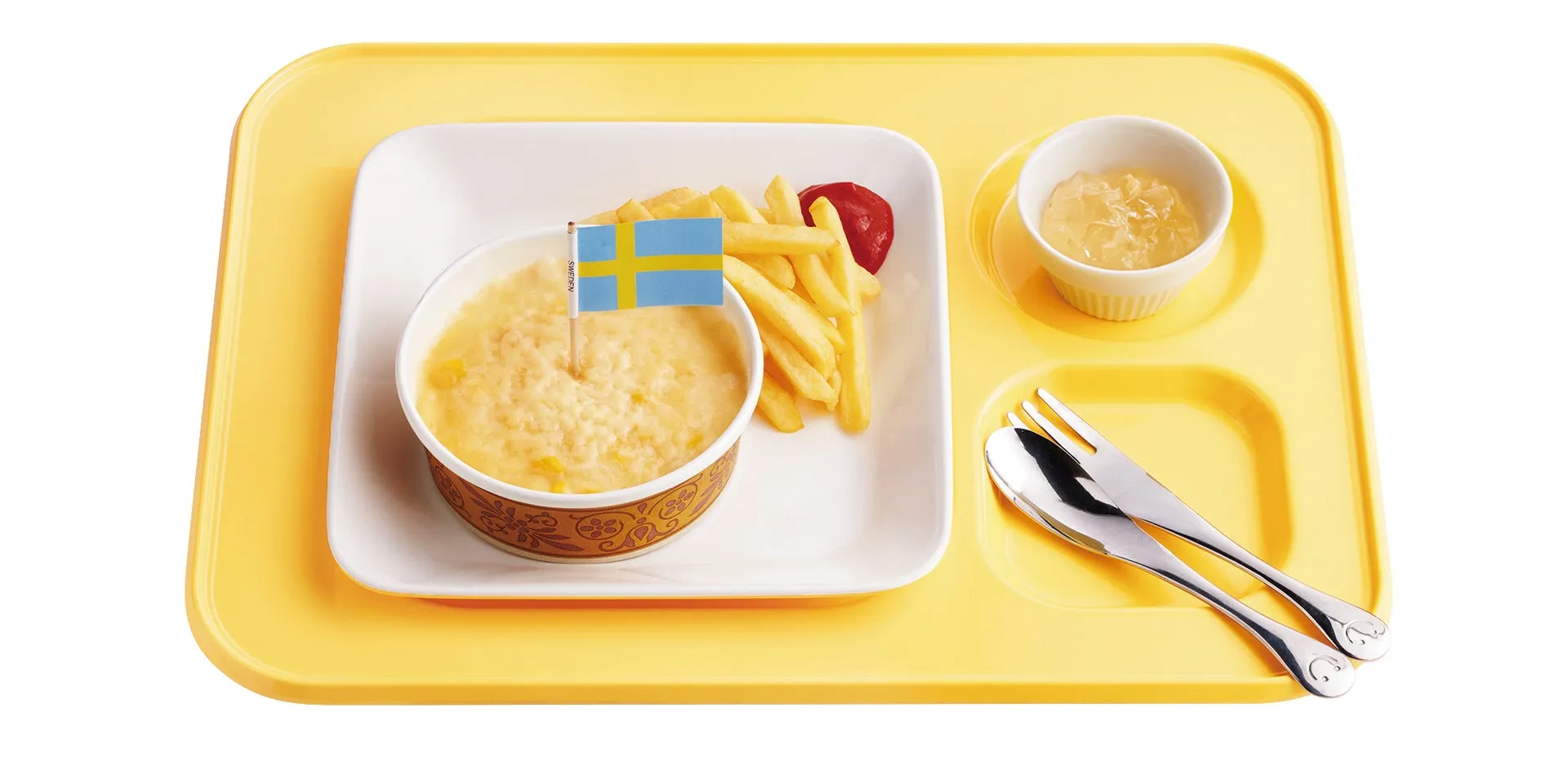 スウェーデンの国旗が刺さったおかゆとフライドポテト、ジャム、カトラリーが載った黄色い給食のトレイ