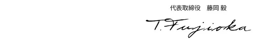 署名が書かれた画像です。「代表取締役 藤岡 毅」と書かれた上に「T.Fujioka」と署名されています。