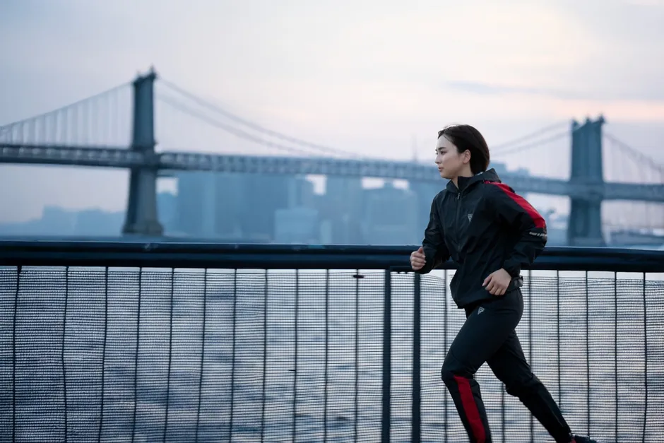 橋を背景に走る女性