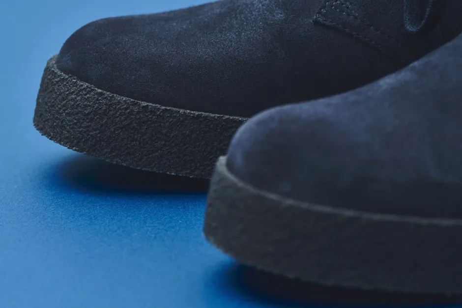 紺色のスエードブーツのクローズアップ写真。ブーツは青い背景に置かれています。