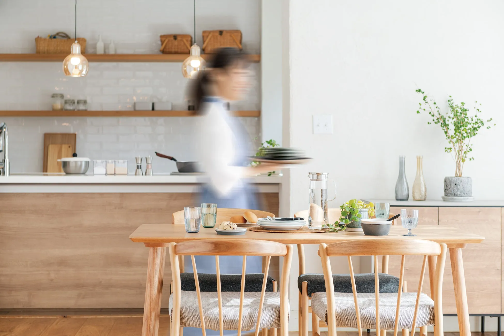 ダイニングテーブルで食事の準備をする女性