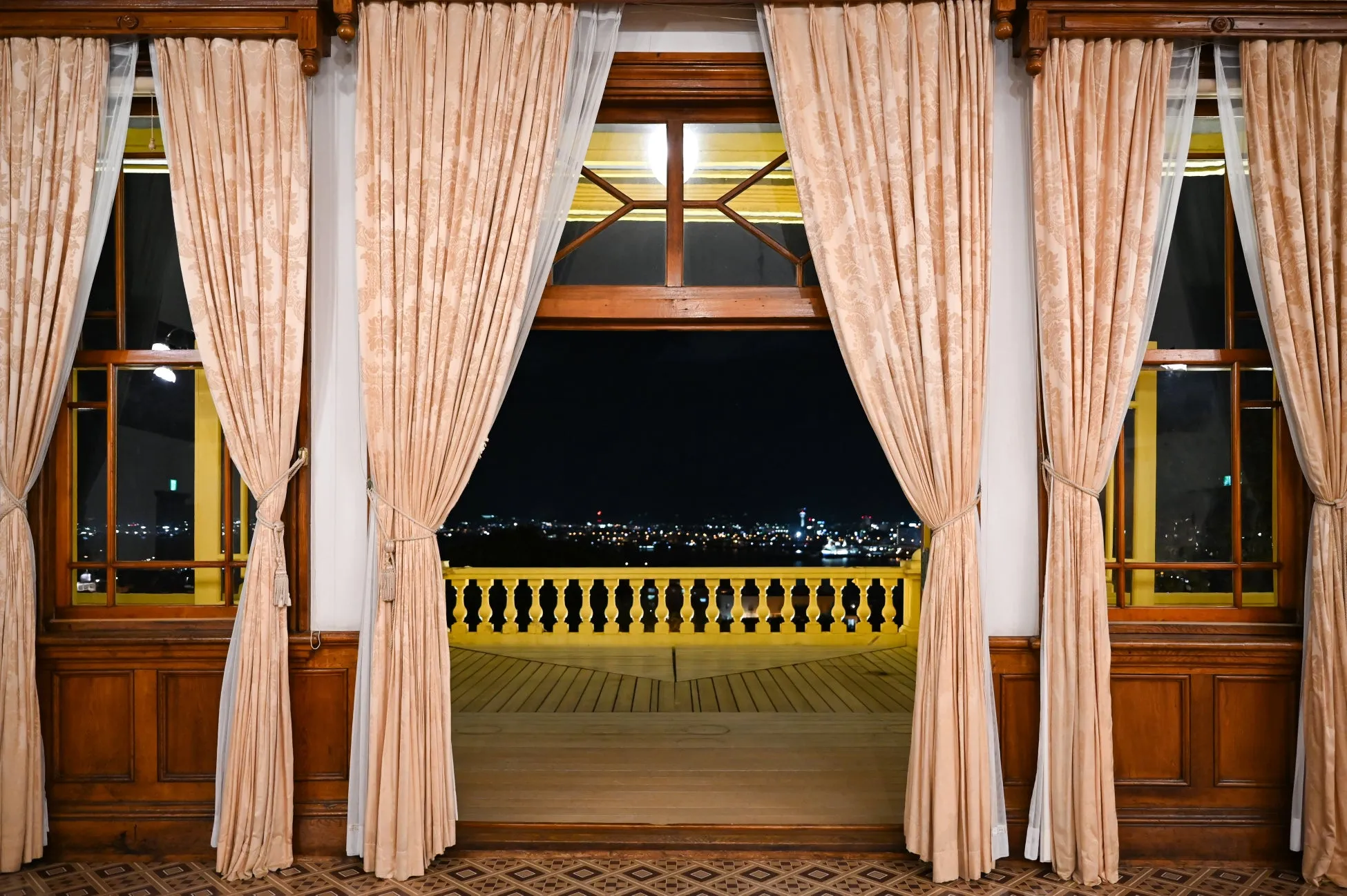 カーテン越しに見える夜景の写真