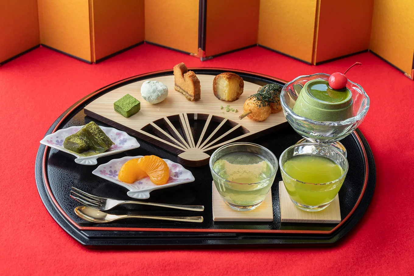 和風デザートの盛り合わせの写真です。抹茶のゼリー、みかん、お団子、お茶などが写っています。