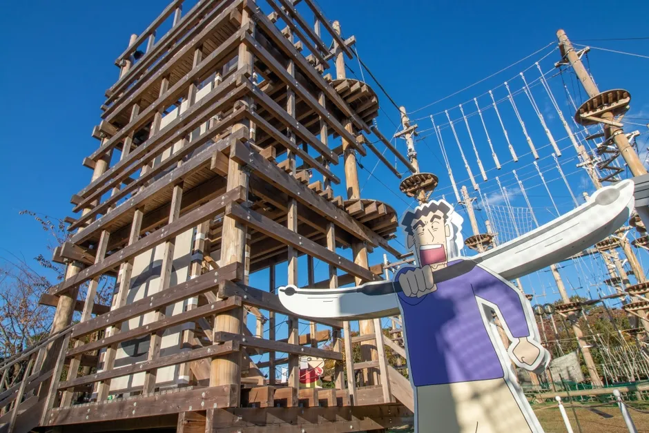 木製の構造物とキャラクターのイラストが描かれた屋外の遊具施設
