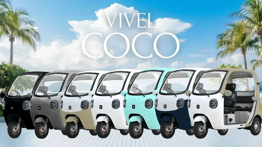 カラフルな電動三輪車の画像。様々な色が並んでおり、背景にはヤシの木と青い空が写っています。