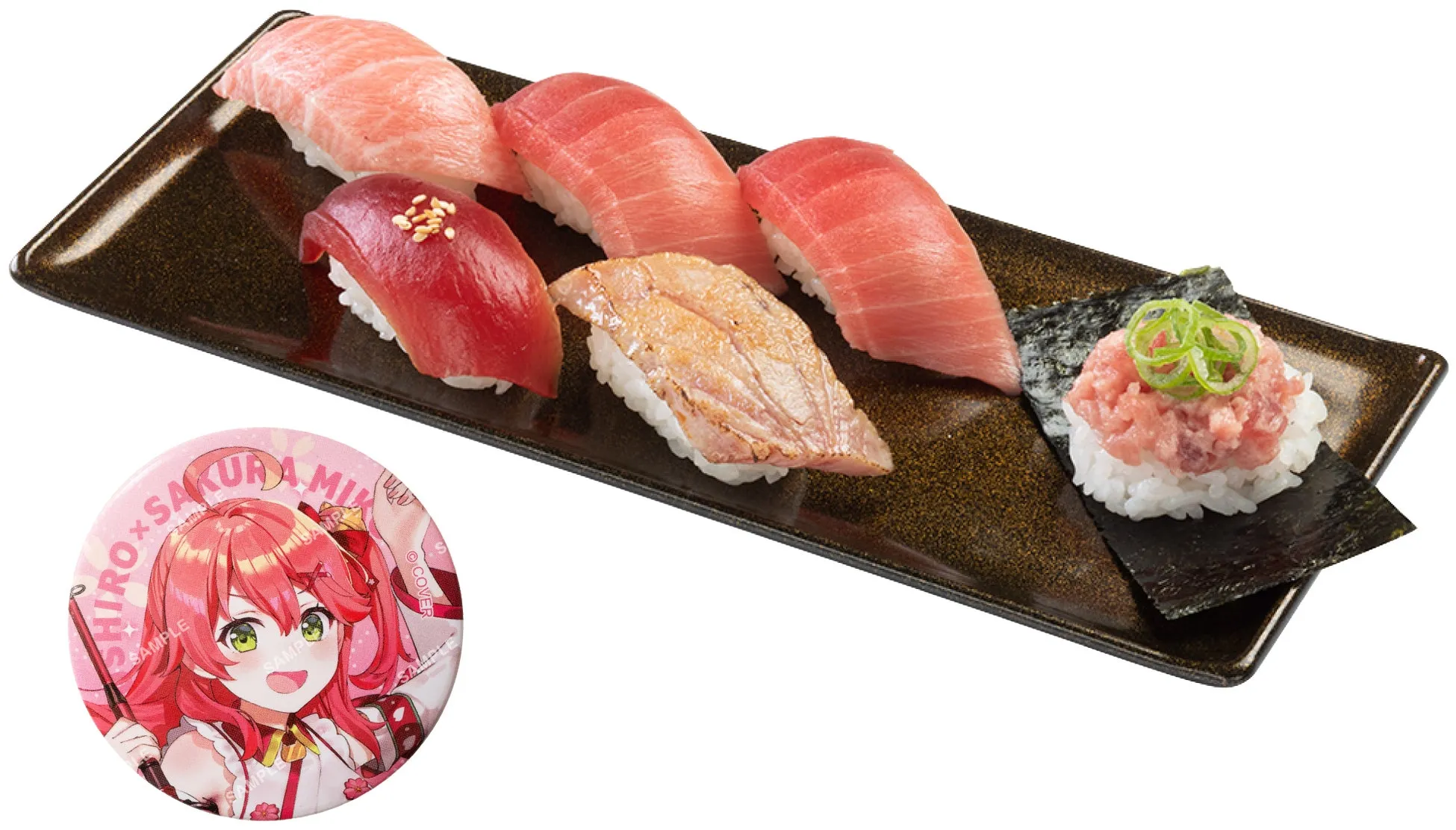 お寿司の盛り合わせと、キャラクターのバッジが写っている写真