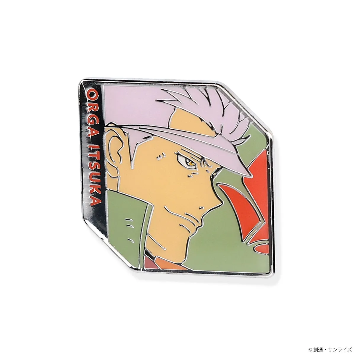 キャラクター「オルガ・イツカ」のイラストが描かれたバッジ。背景は緑色と赤色で彩られ、キャラクターの顔がクローズアップされています。