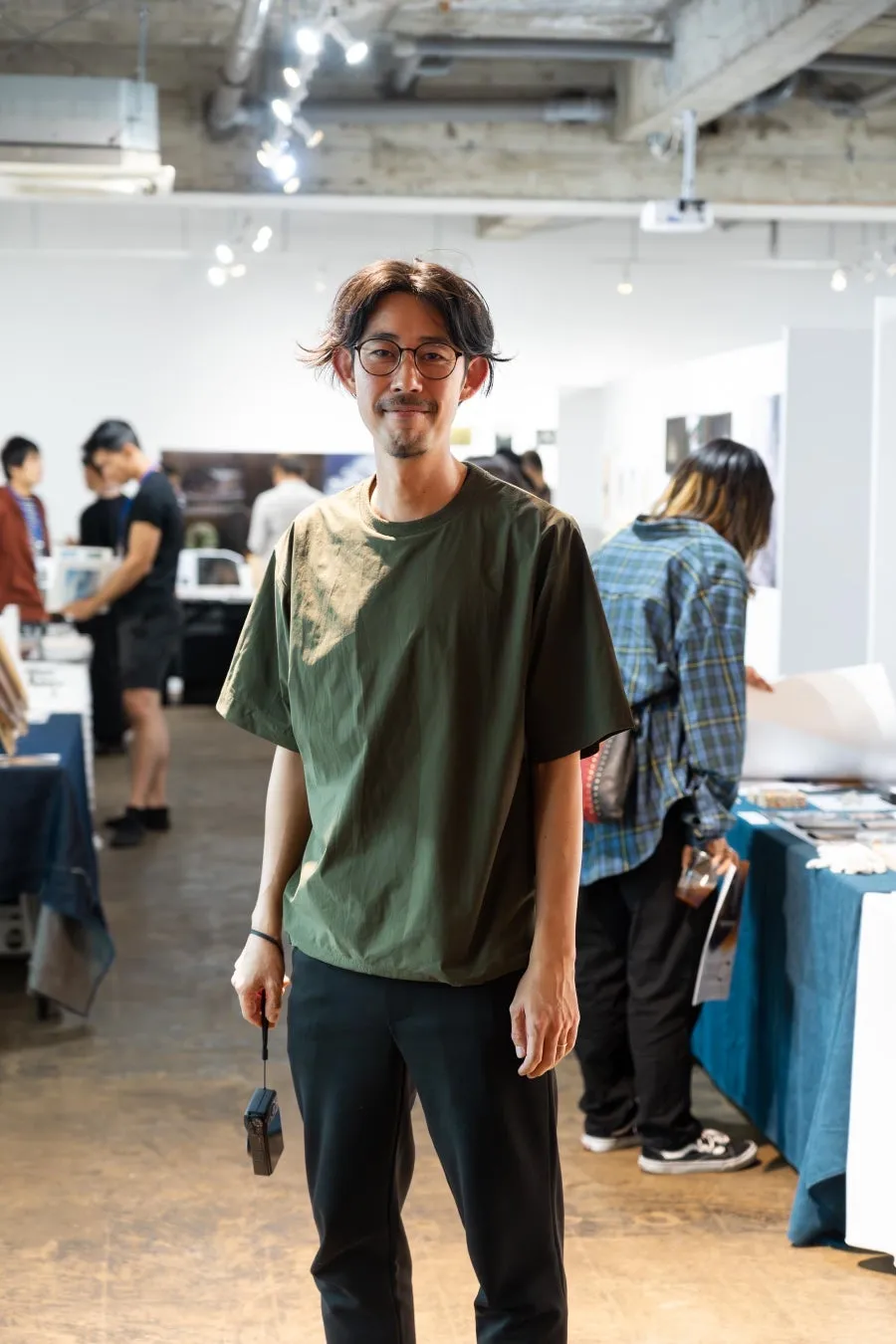 笑顔でカメラを持つ男性 (クリエイティブチームメンバー)