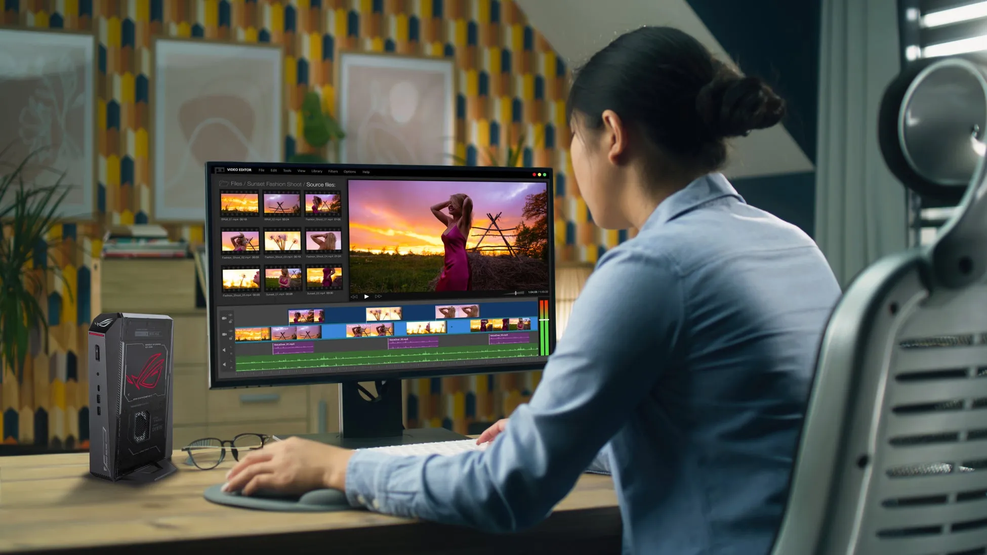 女性が動画編集ソフトを使用している様子。画面には夕焼けを背景にした女性の映像が映し出され、編集作業が行われている。机にはパソコンとモニター、マウスパッド、そしてROGのロゴが入った小型PCが置かれている。