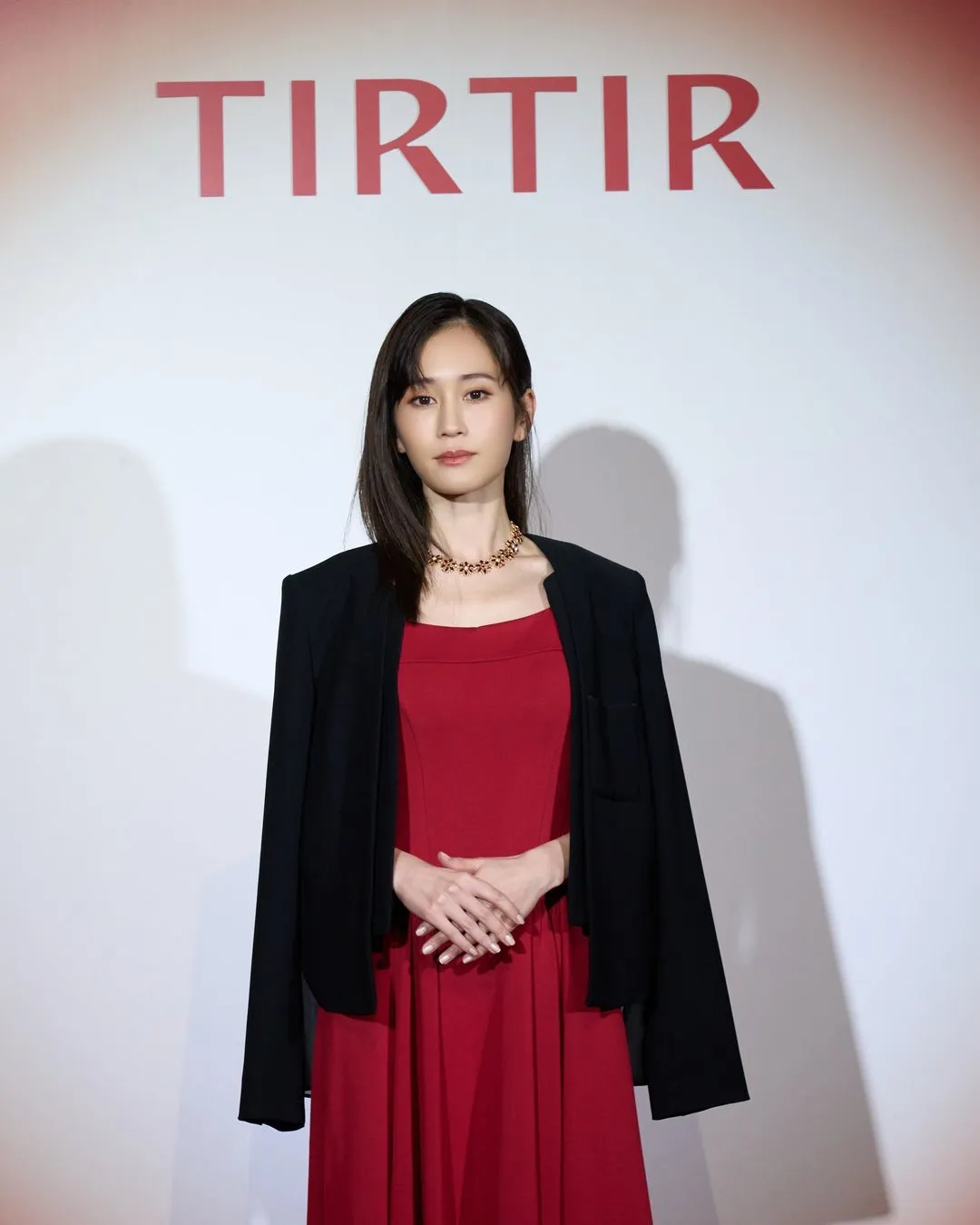 女性がTIRTIRロゴの前でポーズ