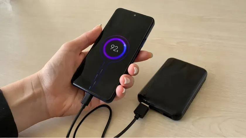 スマートフォンがモバイルバッテリーで充電されている様子。画面には充電状況が表示されており、長寿命を暗示