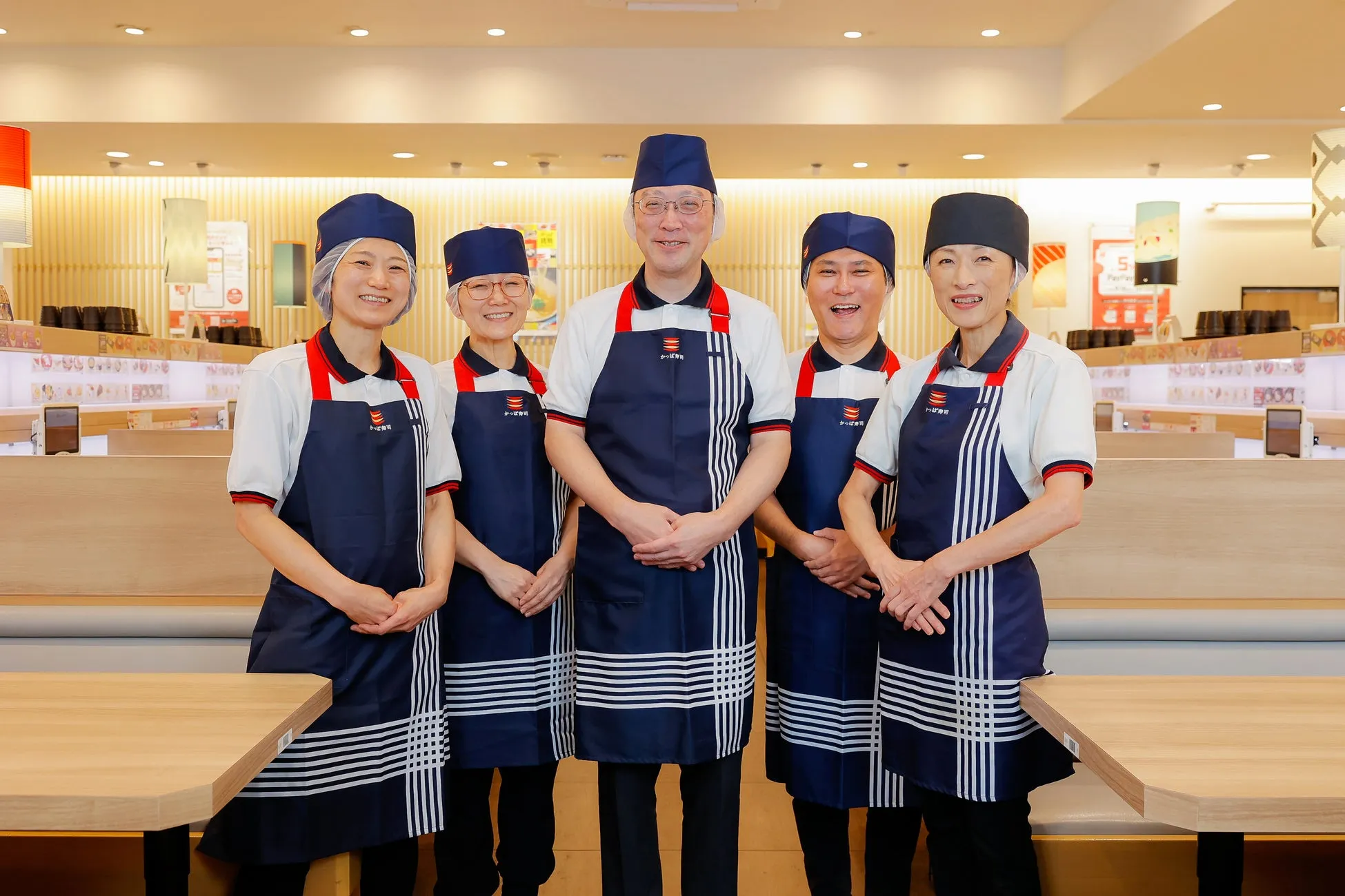 かっぱ寿司の店員が笑顔で写っている写真です。