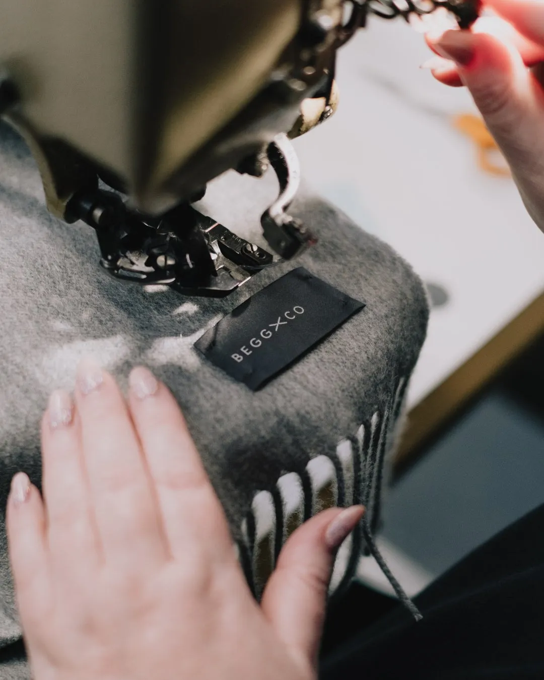 手縫いの様子を捉えた写真、タグにはBEGGXCO