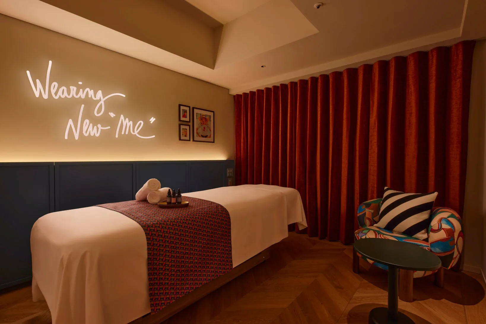 スパトリートメントルーム。マッサージベッド、タオル、製品、椅子、カーテン、装飾された壁と床。