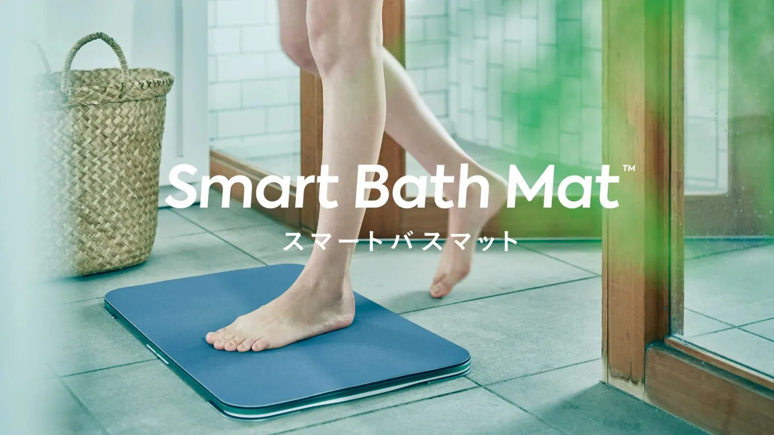 お風呂場のスマートバスマットの広告写真です。足が写っており、マットに足をかけている様子が写っています。背景には、かごやドアがあります。