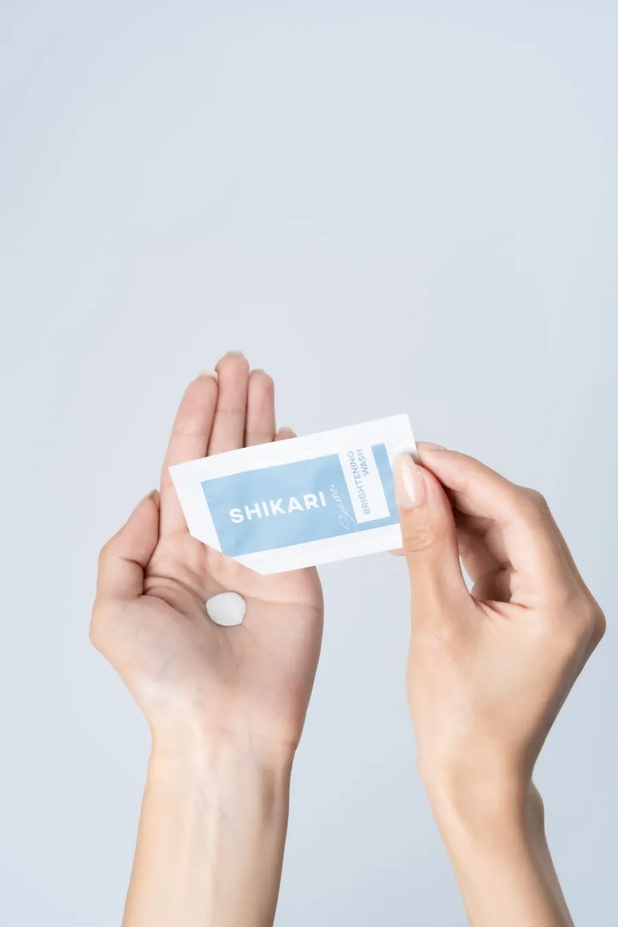 手のひらにSHIKARIの洗顔料と思われるものと、その中身と思われる白い丸いものを持っている様子を写した写真です。