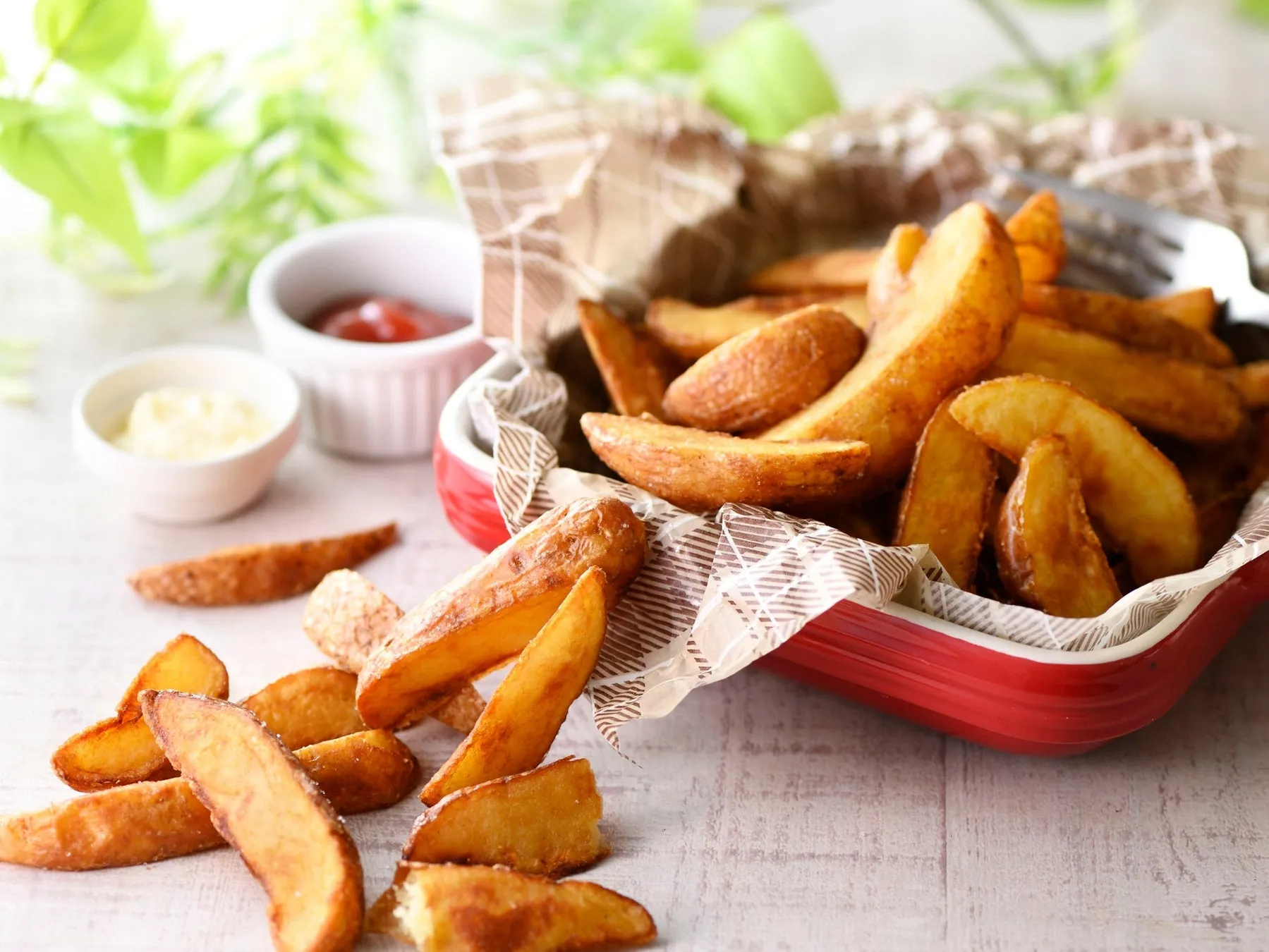 揚げたてのアメリカンフライドポテトが赤い容器に入っていて、ケチャップとマヨネーズが添えられている写真です。
