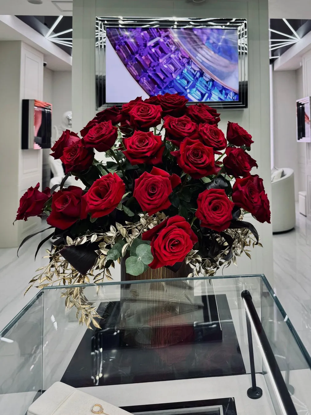 赤いバラの花束がガラスケースに飾られている写真