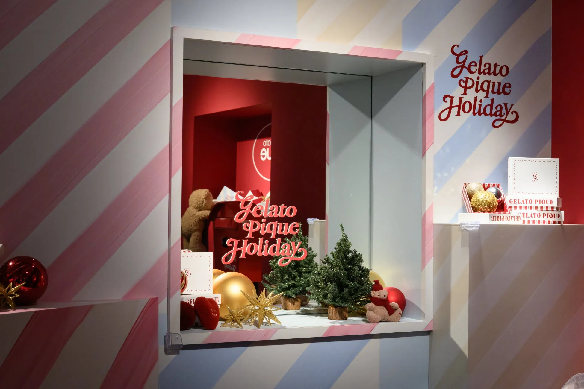 ジェラートピケのホリデーディスプレイ。ウィンドウには、クリスマスオーナメント、テディベア、クリスマスツリーが飾られています。