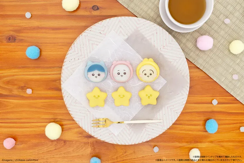 お菓子が並んだ写真。キャラクターを模した丸いお菓子と星型のお菓子が、お皿の上に置かれている。周りには、カラフルなポンポンや飲み物も見える。