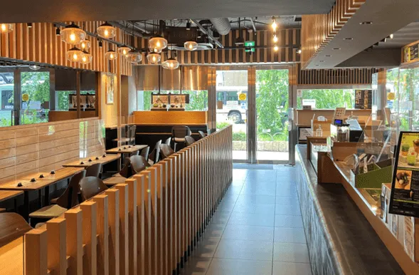 店内。木材を基調とした内装で、テーブル席とカウンター席がある。窓からは外の景色が見える。