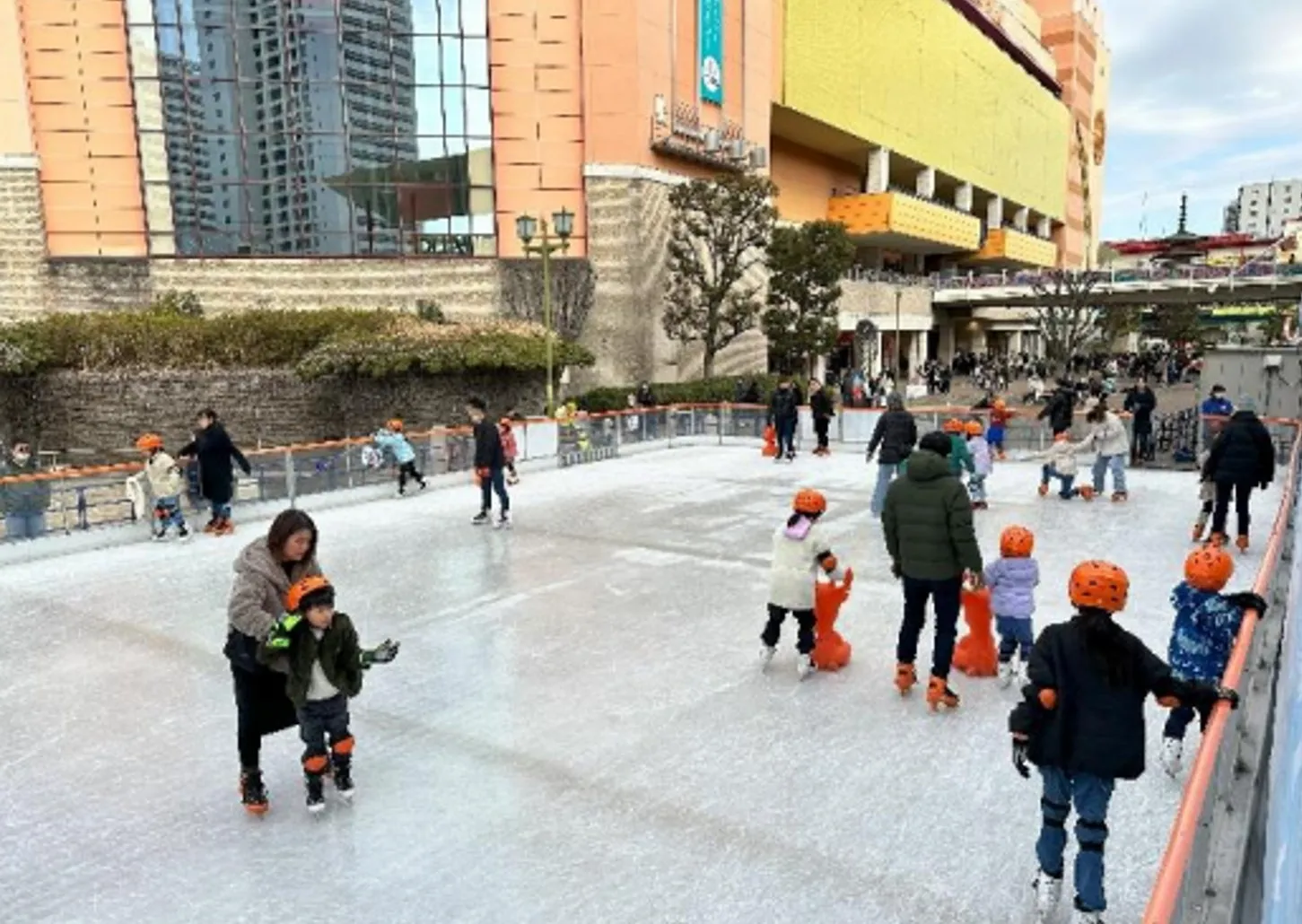 屋外のスケートリンクで、子供たちがスケートを楽しんでいる様子。