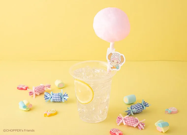 黄色い背景に、コップに入った飲み物と綿あめ、キャンディが置かれている写真です。飲み物はレモンが添えられ、チョッパーのイラストが飾られています。