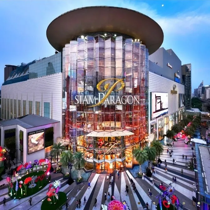 サイアムパラゴンショッピングモールの外観です。ガラス張りの建物で、多くの人が歩いています。ルイ・ヴィトンの看板も見えます。