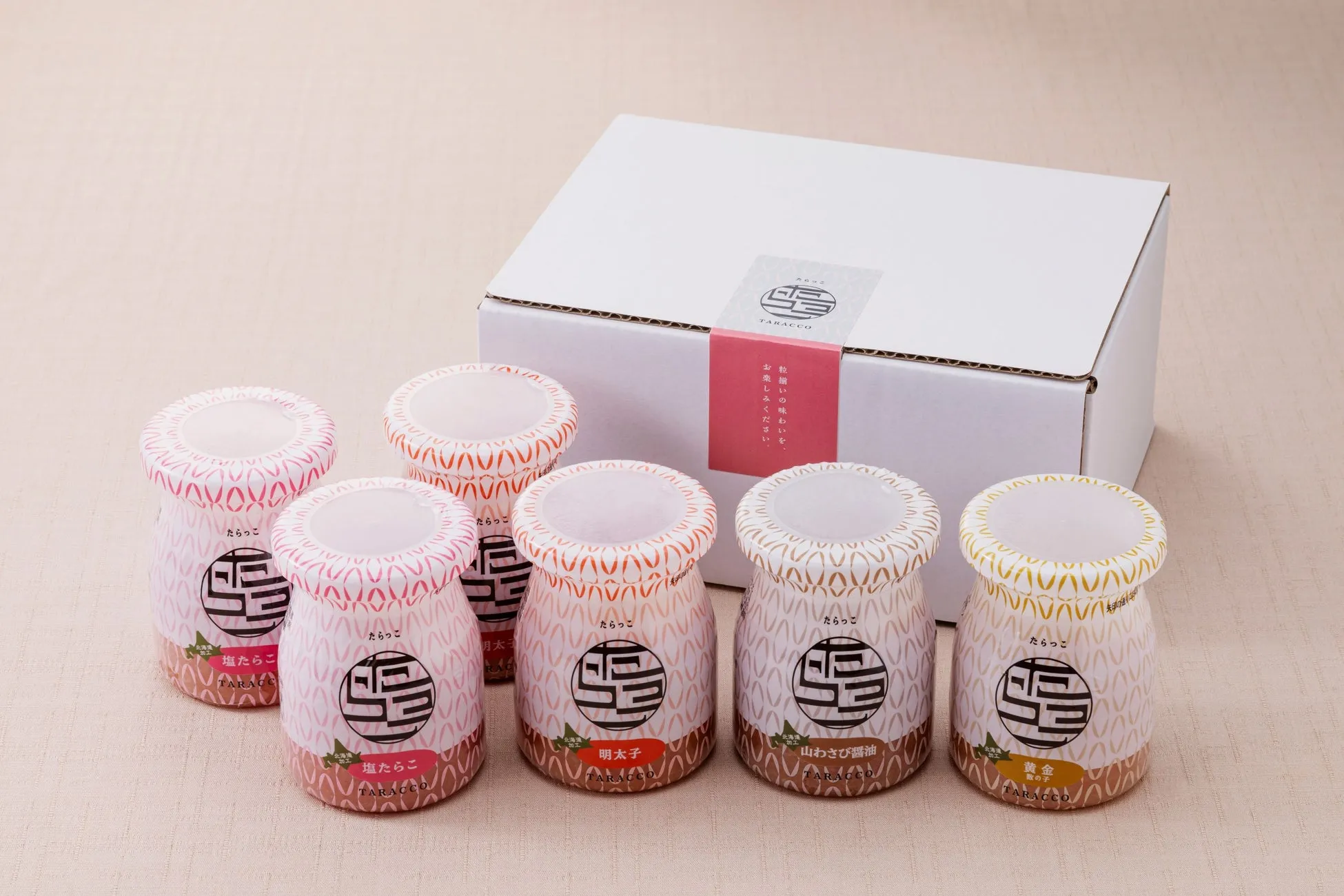 たらこの瓶が6つと、それらが入った箱が写っている。瓶にはそれぞれ異なるフレーバー名が書かれており、ギフトセットとして販売されているようだ。