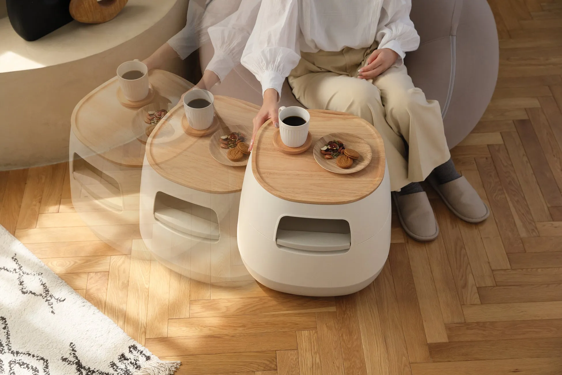 女性がコーヒーとクッキーのテーブルに座る画像