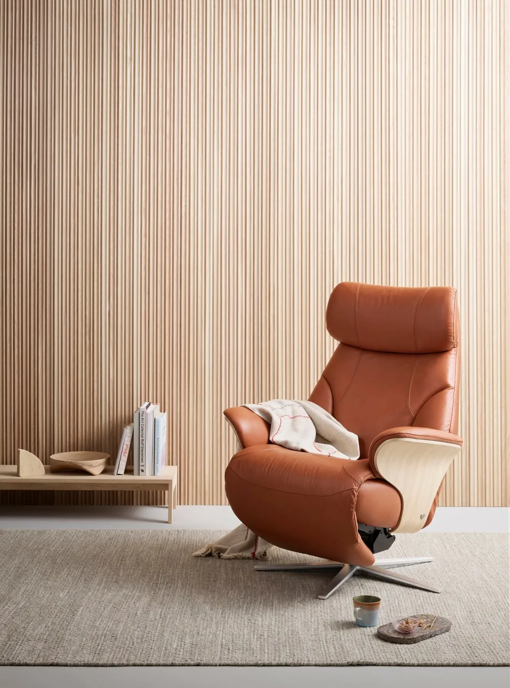 茶色の革張りのリクライニングチェアが、木製の壁とじゅうたんのある部屋に置かれている画像です