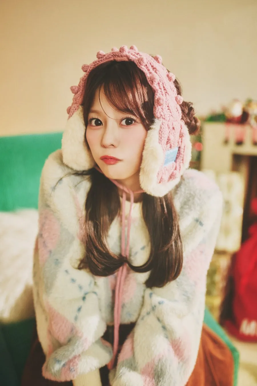 ピンクのニット帽をかぶり、ふわふわの服を着た女性のポートレートの画像