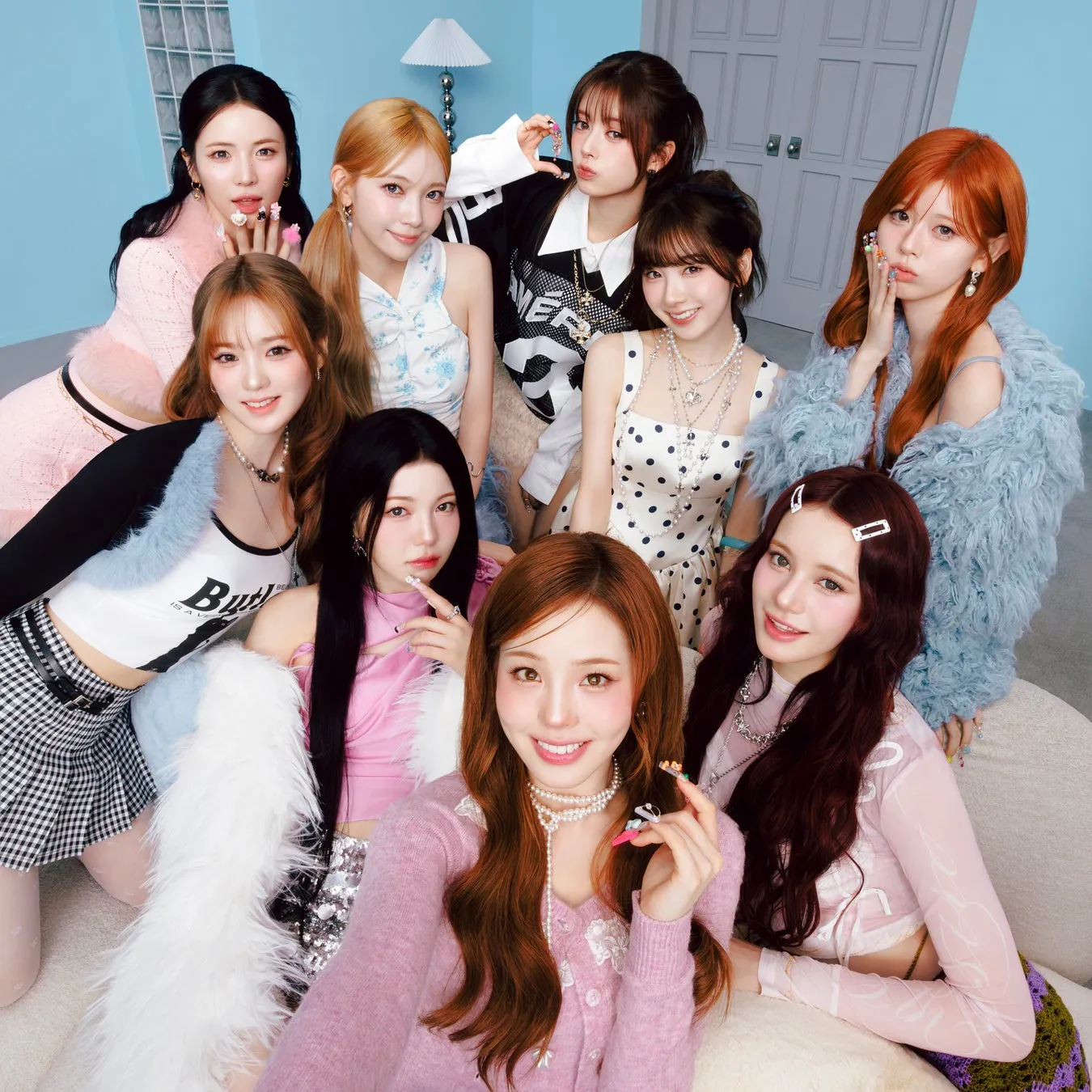 9人の女性がソファに座ってポーズをとっている写真