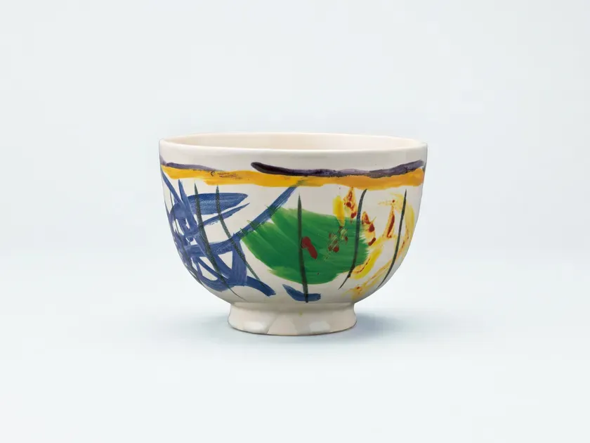 カラフルな絵柄が描かれた陶器の器の画像です。器は白く、青、緑、黄色などの鮮やかな色が使われています。器の表面には、抽象的な模様が描かれており、芸術的な印象を与えます。